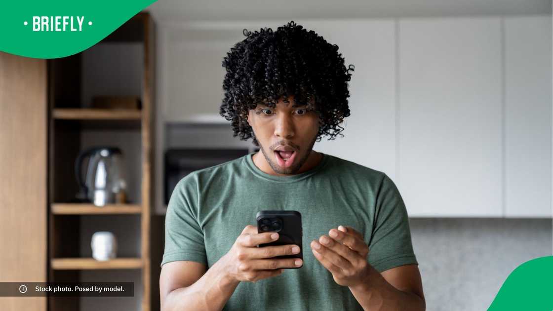 A shocked man looking at his phone. A shocked man looking at his phone.
