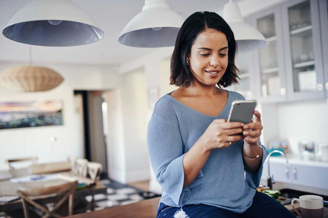 A woman smiling at her phone. A woman smiling at her phone.