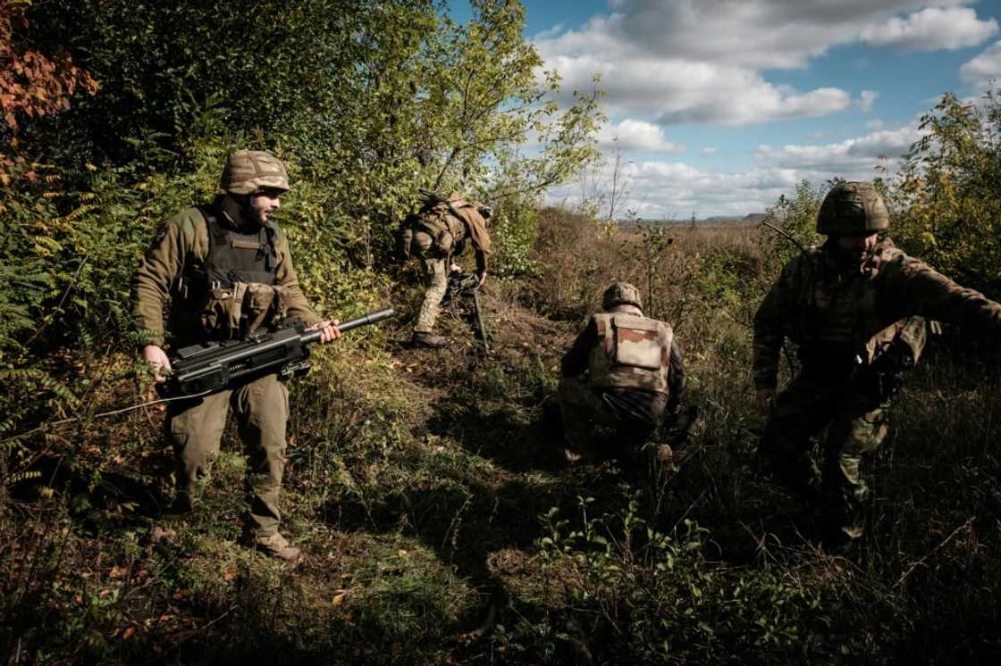 Ukrainian soldiers prepare an automatic grenade launcher on the front line near Toretsk in the Donetsk region on October 12, 2022