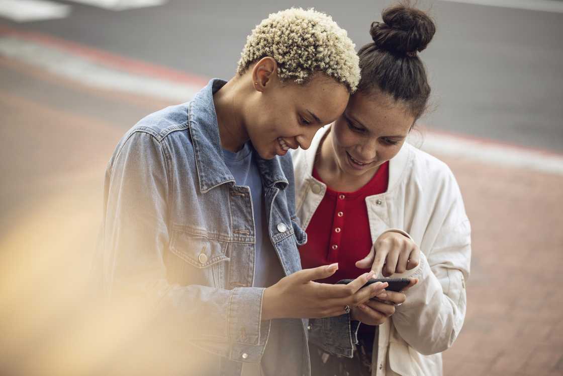 Two women looking at a phone. Two women looking at a phone.