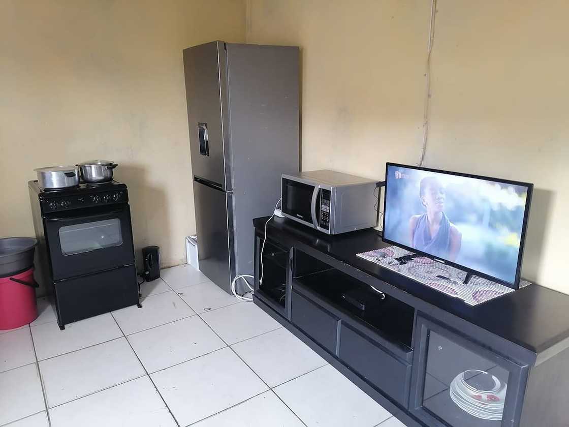 Young lady showcases her kitchen and TV area