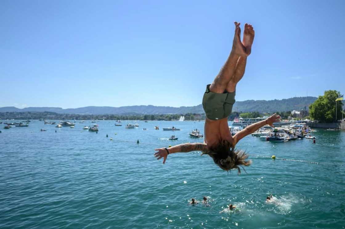 The river's banks were full of revellers, many taking the plunge into the water to keep cool