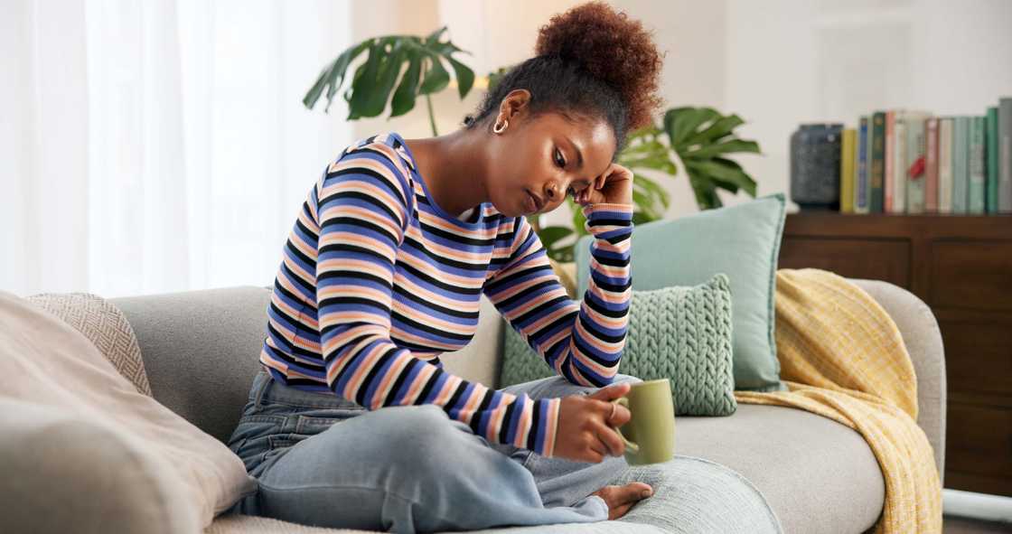A sad lady holds a cup of coffee