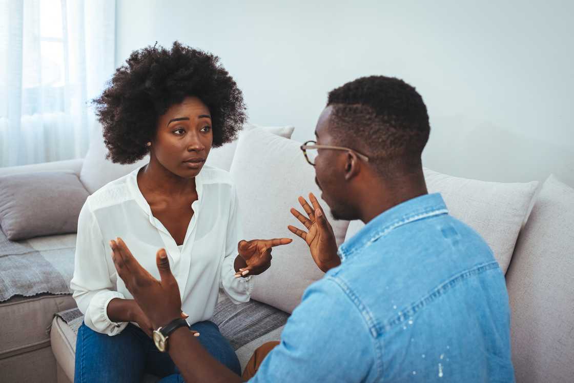 A young couple sitting on the couch having a family fight. A young couple sitting on the couch having a family fight.