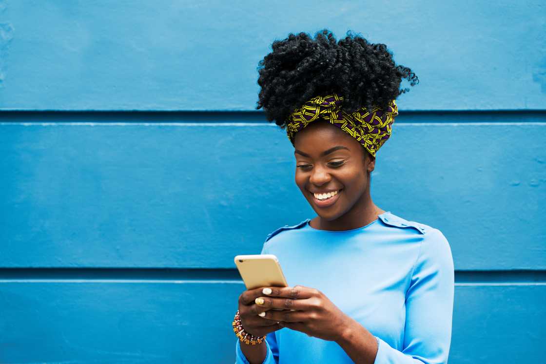 A woman smiling at her phone. A woman smiling at her phone.