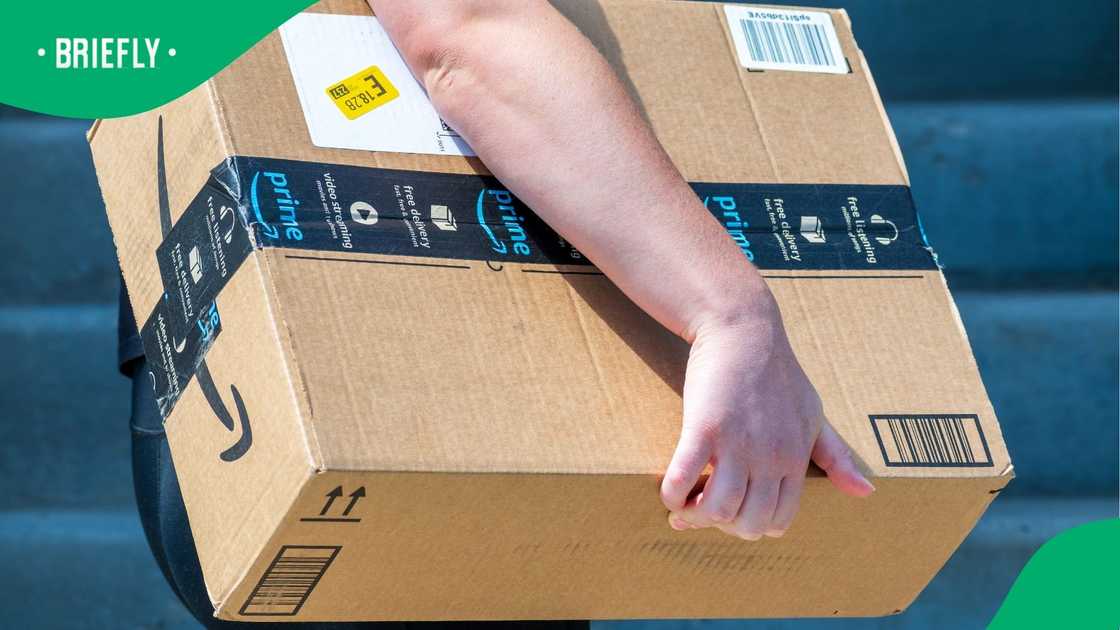 An Amazon Flex driver delivers a large cardboard box to a residential doorstep. An Amazon Flex driver delivers a large cardboard box to a residential doorstep.