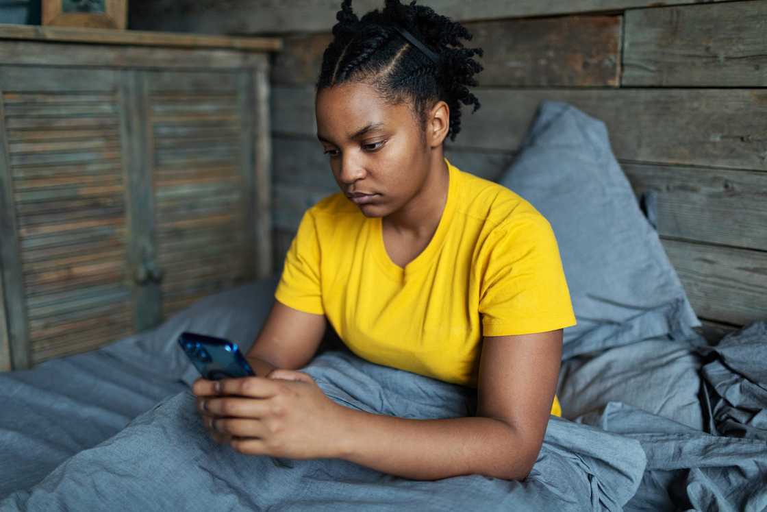 A sad lady is using her phone