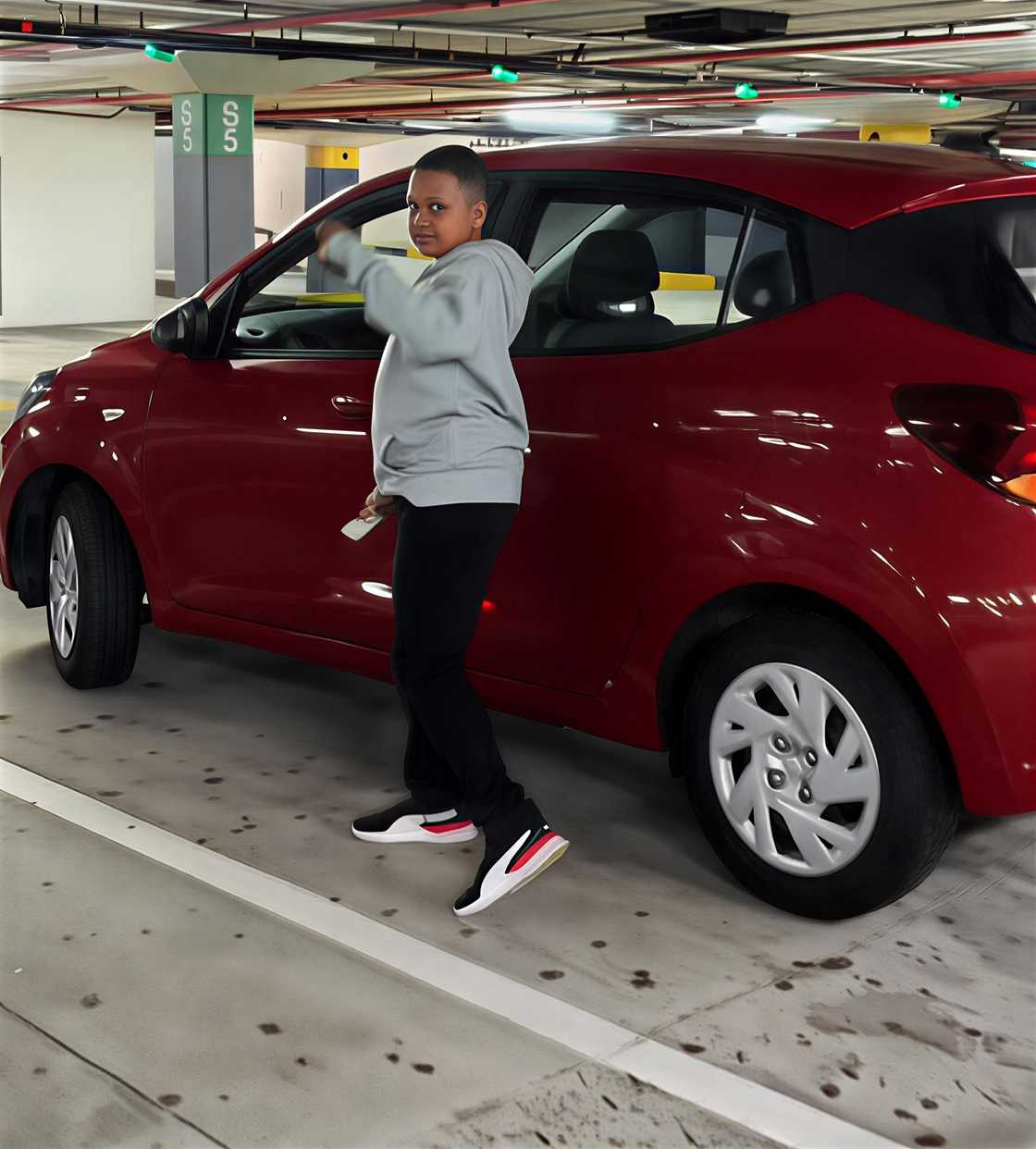 A young 11-year-old boy stood in front of his brand-new car.