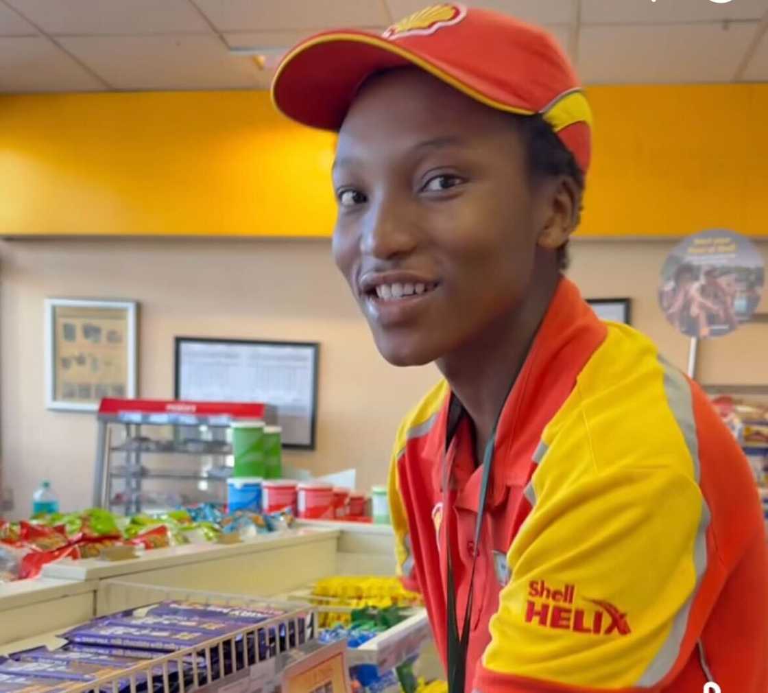 A petrol attendant was captured packing snacks on the shelves in a store. A petrol attendant was captured packing snacks on the shelves in a store.