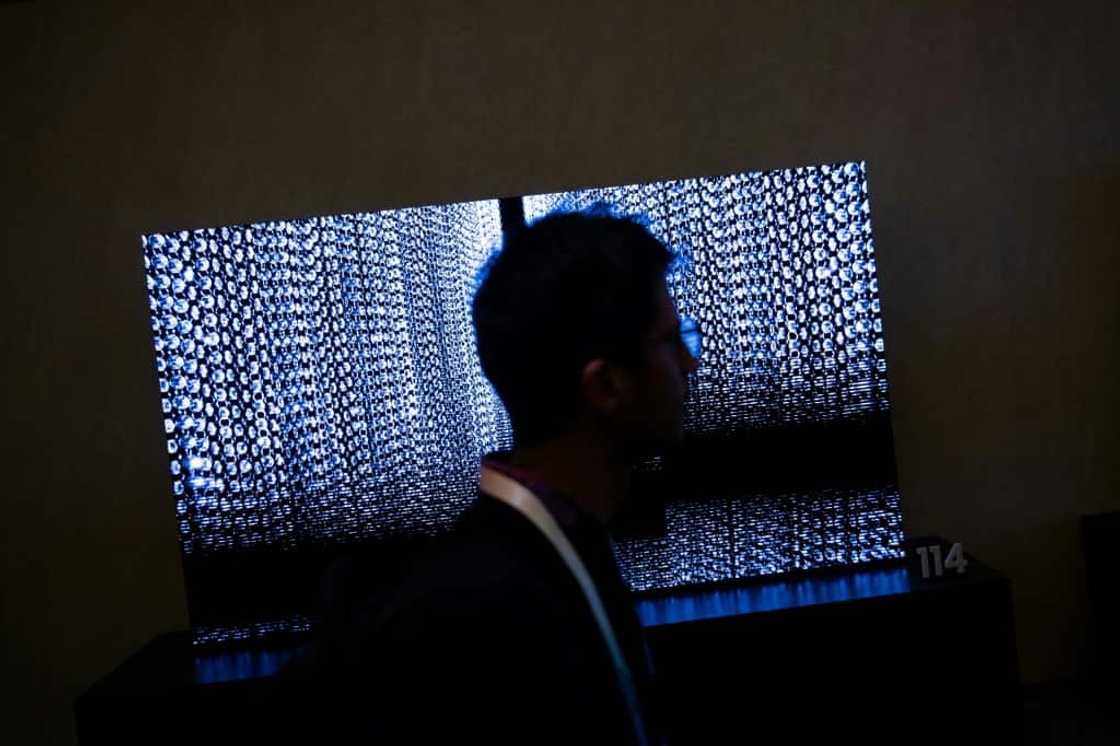 A person walks past TV screens at the Samsung First Look preview at the Caesars Palace resort, a pre-show for this weeks Consumer Electronics Show January 7, 2024, in Las Vegas, Nevada.