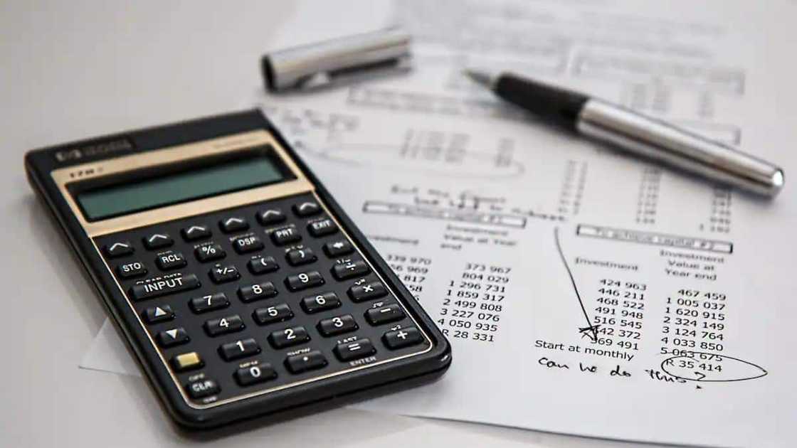 A picture of a calculator and financial sheets A picture of a calculator and financial sheets