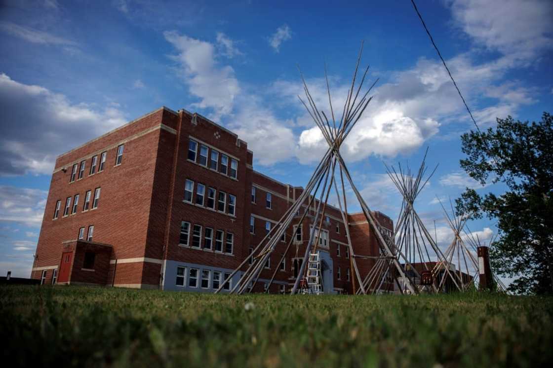 Skeletal poles of teepees outside the University nuhelt'ine tahiyots'i nistameyimakanak Blue Quills in St. Paul, Alberta