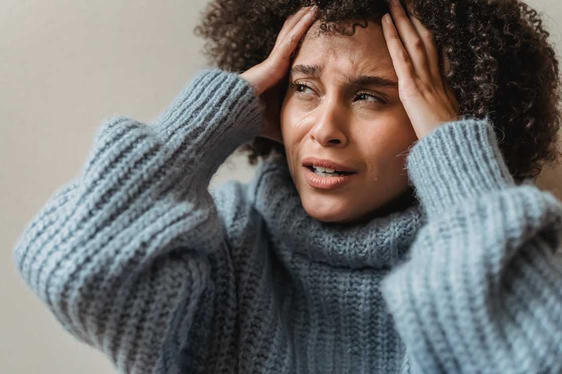 Close-up of a distressed woman holding her head in frustration. Close-up of a distressed woman holding her head in frustration.