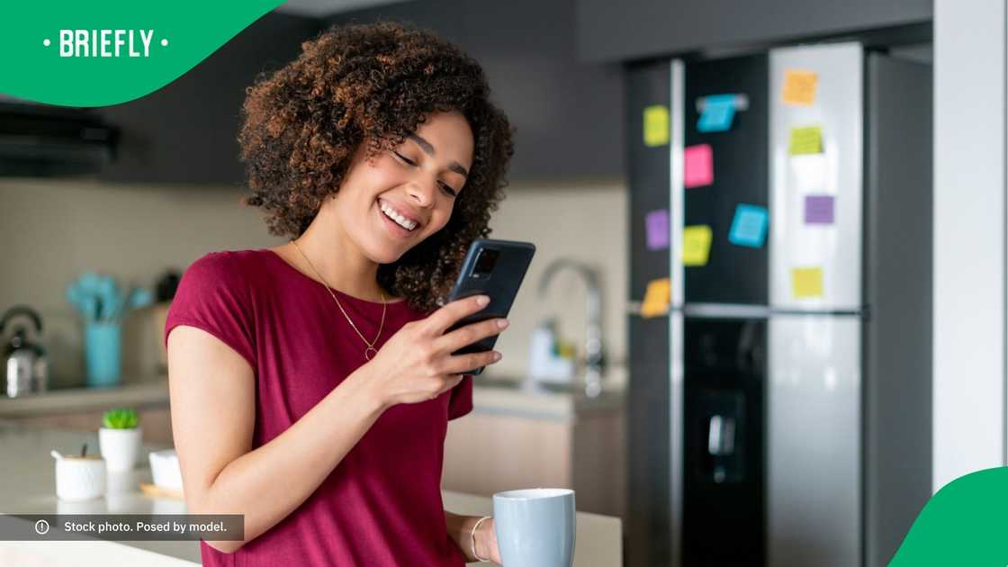 A woman laughing at her phone.