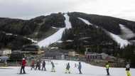 Alpine tourists ski amid brown hillsides