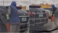 Mobile car wash: Massive reactions as young man washes moving vehicle, video goes viral