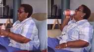 Video of old mama enjoying an ice cold bev after a long day has Mzansi in stitches: “She deserves it”