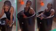 Lady dips herself inside big drum filled with cold water after she could not go to swimming pool