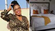 Creative lady with pretty smile transforms bedroom into fab hotel-like space