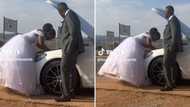 Video of bride fixing car in wedding dress while groom watches sparks debate