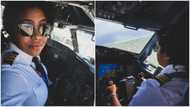 Beautiful female pilot poses in aeroplane, many people react