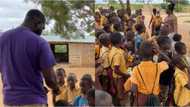 Kind woman gives lunch, school supplies and backpacks to pupils in Africa