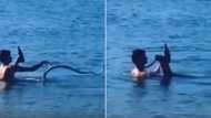 The booze will not fall: Man fights snake in ocean, doesn’t spill a drop of drink