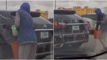 Mobile car wash: Massive reactions as young man washes moving vehicle, video goes viral