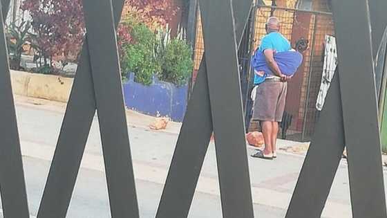 Mzansi swoons over grandpa carrying little one on his back with towel