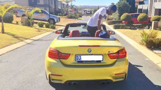 Local DJ celebrates the "small things" while posing in his luxury BMW