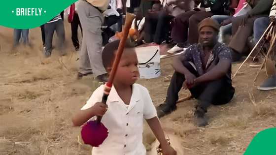Zulu kid leads men in traditional chant and dance at gathering in video