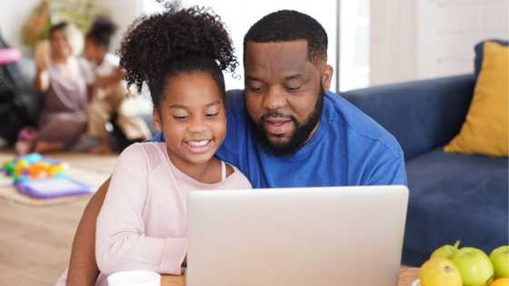 Picture of father and daughter sitting in the mall to use the free Wi-Fi to do school work breaks many hearts